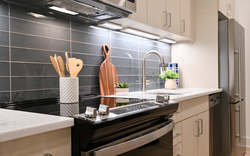 Kitchen with white cabinets and dark subway tile backsplash
