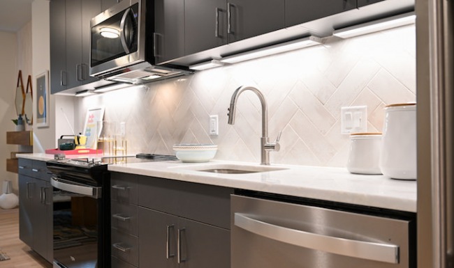 kitchen detail charcoal cabinets and white herringbone backsplash